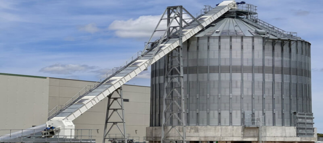 Biomass silo integrated with mechanical conveying and screw extraction system